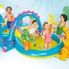 Kids playing in colourful inflatable dinosaur pool.