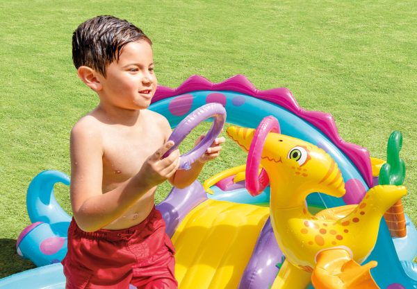 Child playing with inflatable dinosaur in garden