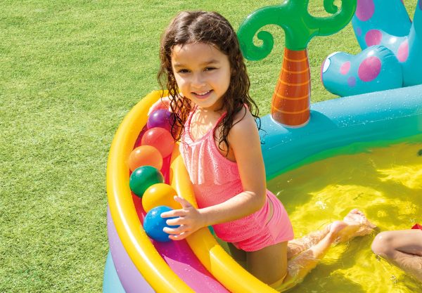Child playing in colourful inflatable pool with balls.