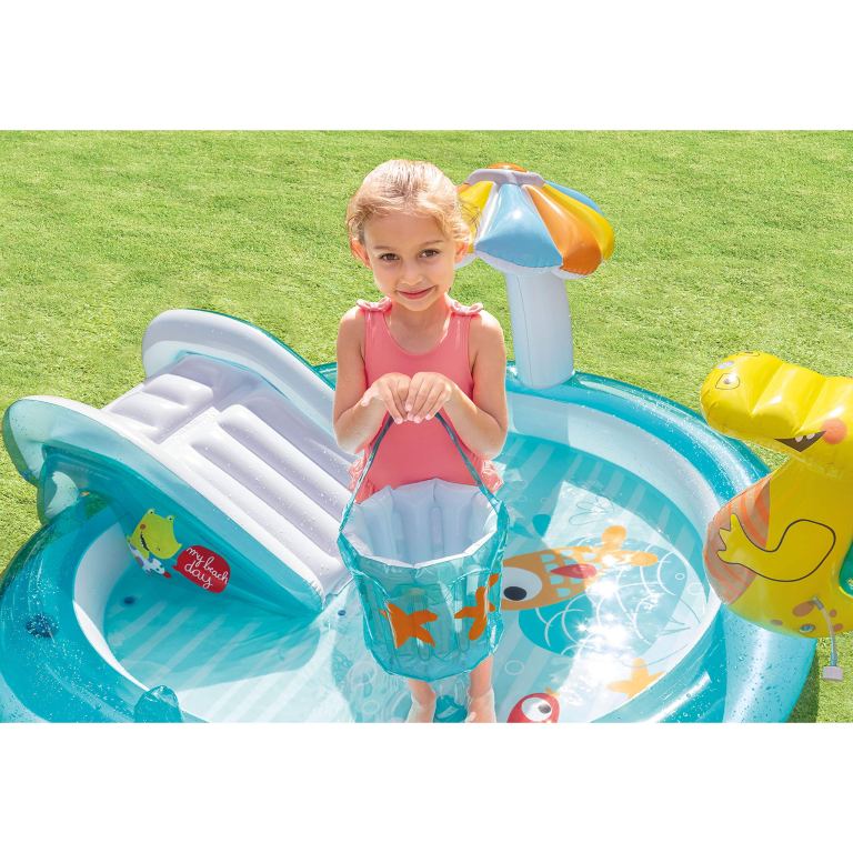 Child playing in inflatable kiddie pool with bucket.