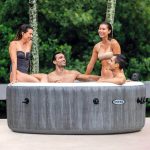 intex purespa 6 person greywood spa 28442 Four people enjoying an outdoor spa on patio.
