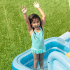Child playing in inflatable pool outdoors.