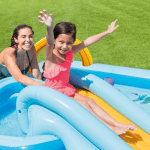 Woman and girl enjoying inflatable pool slide.