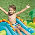 intex little dino inflatable play centre 57166 Child playing on inflatable dino pool, grass background.
