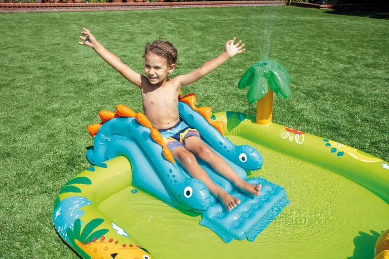 intex little dino inflatable play centre 57166 Child sliding on inflatable dinosaur pool toy.