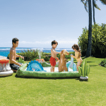 intex jurassic adventure inflatable play center 56132 Kids playing in inflatable pool by the beach.