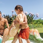 intex jurassic adventure inflatable play center 56132 Child in pool with inflatable dinosaur toy.