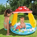 Mother and child enjoying inflatable pool outdoors.