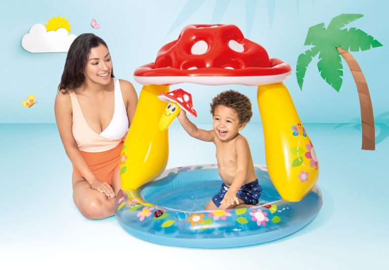 Child plays in colourful mushroom inflatable pool.