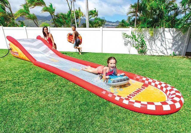 Kids enjoying inflatable backyard water slide