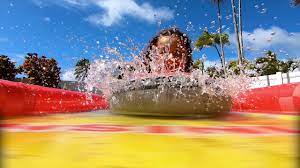 Kid splashing water in inflatable pool outdoors.