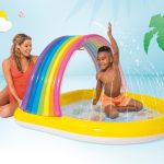 Child plays in rainbow inflatable splash pad
