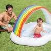 intex rainbow cloud inflatable spray baby pool 57141 Child splashing in rainbow inflatable pool.