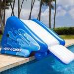 Inflatable blue pool slide next to water