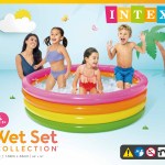 Kids playing in rainbow inflatable pool.