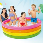 Kids playing in a rainbow inflatable pool.