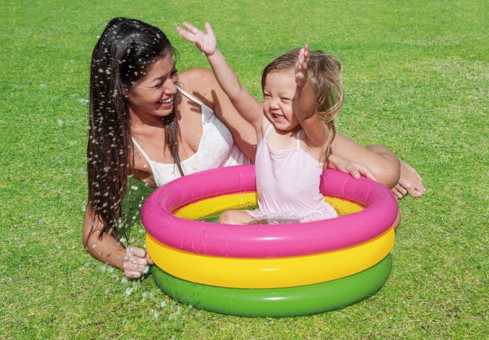 Mother and child playing in a paddling pool.