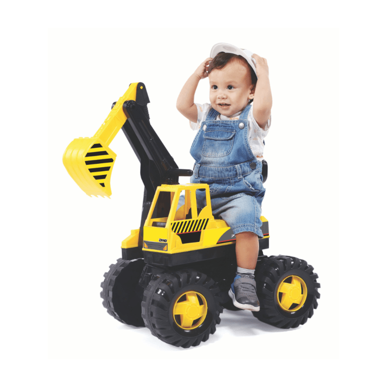 Child on toy digger wearing denim overalls, white hat.