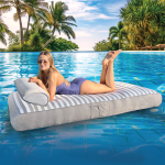 Woman relaxing on inflatable pool mattress, tropical background.
