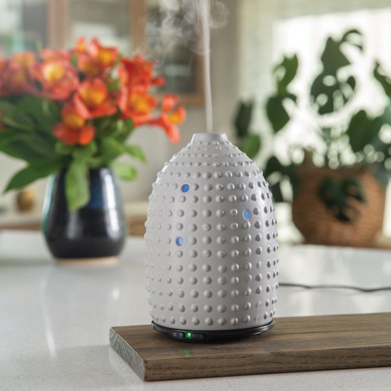 Aromatherapy diffuser with steam on kitchen bench.