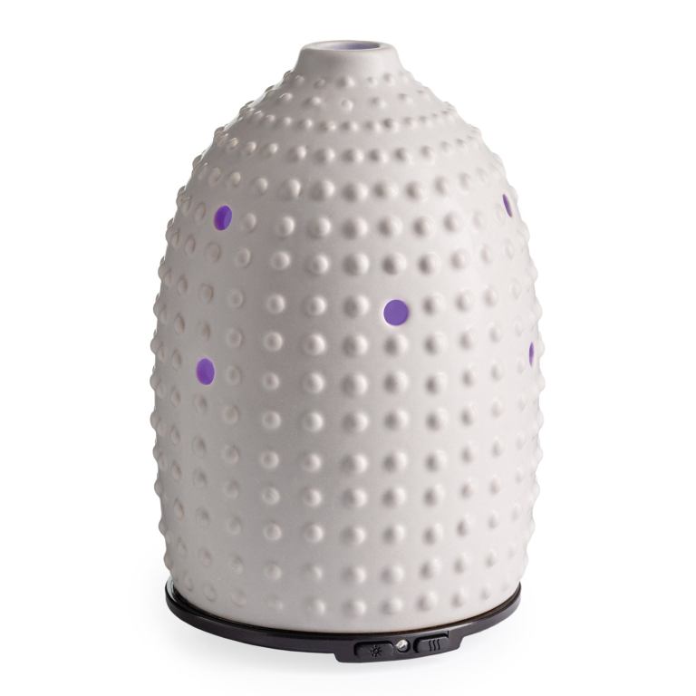 White ceramic essential oil diffuser with perforations.