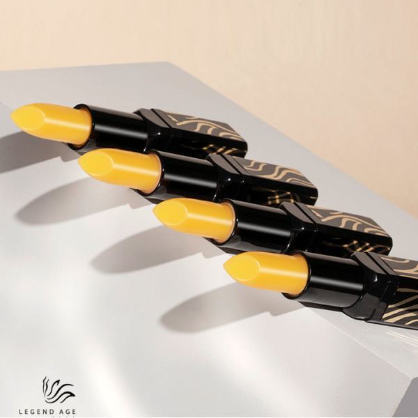 Four yellow lipsticks in black cases on display.