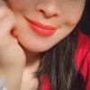 Smiling person with red lipstick, wearing red shirt.