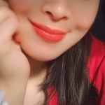 Smiling person with red lipstick, wearing red shirt.