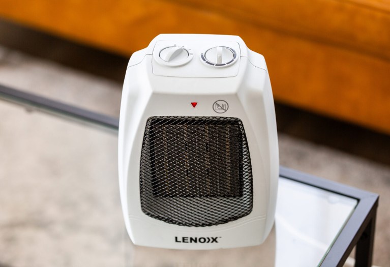 Portable heater with control knobs and mesh front.