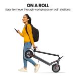 Person carrying foldable scooter while walking.