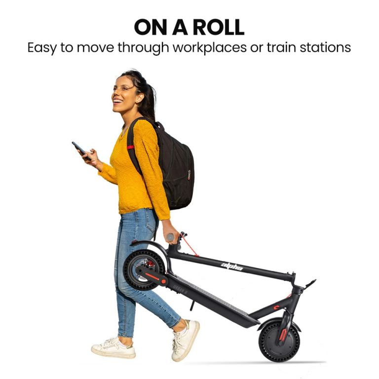 Person carrying foldable scooter, smiling and walking.