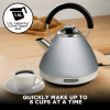 Silver kettle with black handle on kitchen bench.