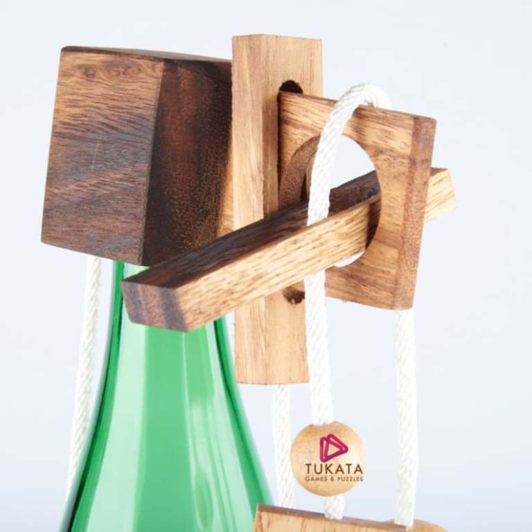 Wooden puzzle game on green bottle, close-up view.