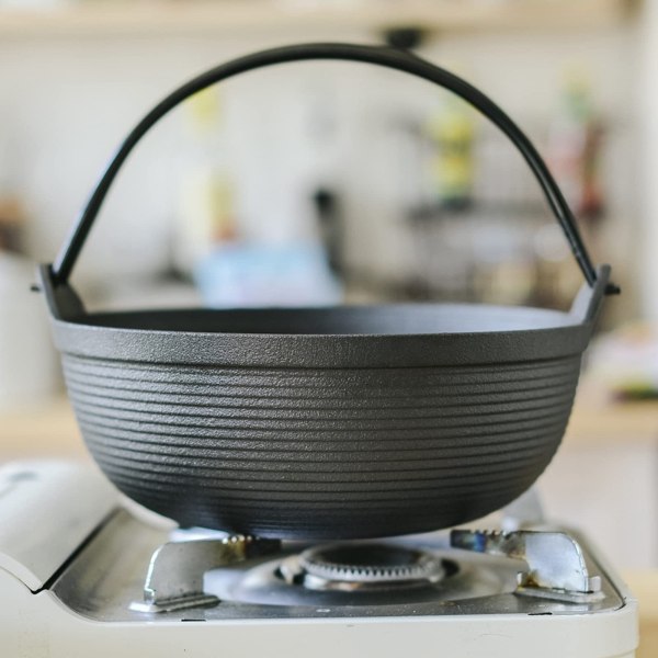 29cm cast iron sukiyaki iron pot japanese shabu shabu pot pan stockpot wooden lid home camping picnic Cast iron pot on gas stove in kitchen.