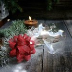 Heart ornaments, pine, candle on wooden table.