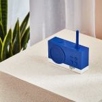 Blue Pantone radio on sandy surface.