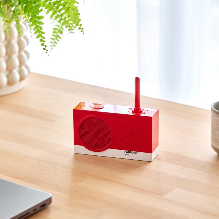 Red Pantone radio on wooden desk