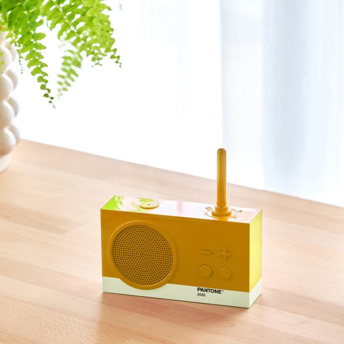 Yellow retro radio on wooden table.