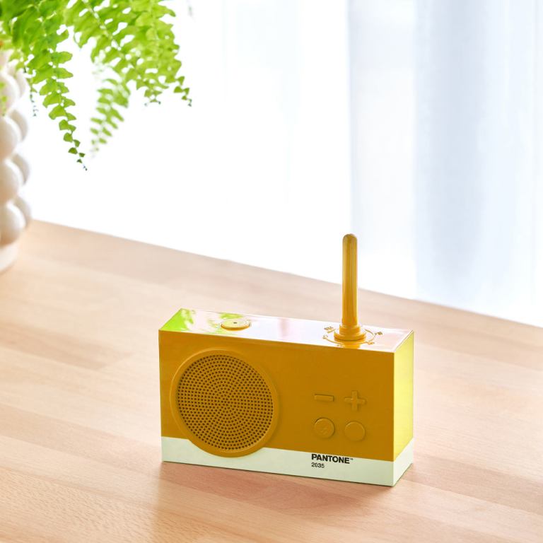 Yellow retro radio on wooden table.