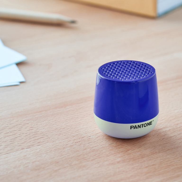 lexon mino+ mini bluetooth speaker pantone classic blue Blue Pantone Bluetooth speaker on wooden desk.