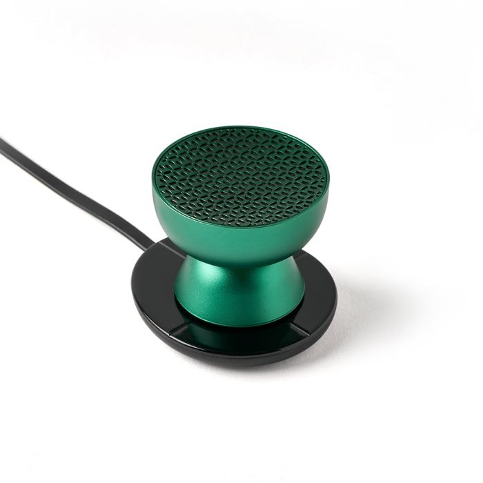 lexon tamo infinitely pairable bluetooth speaker green Green wireless speaker on black charging base.