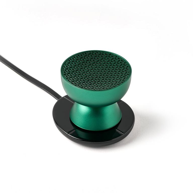 lexon tamo infinitely pairable bluetooth speaker green Green wireless speaker on black charging base.