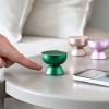 lexon tamo infinitely pairable bluetooth speaker green Hand approaching colourful mini wireless speakers on table.