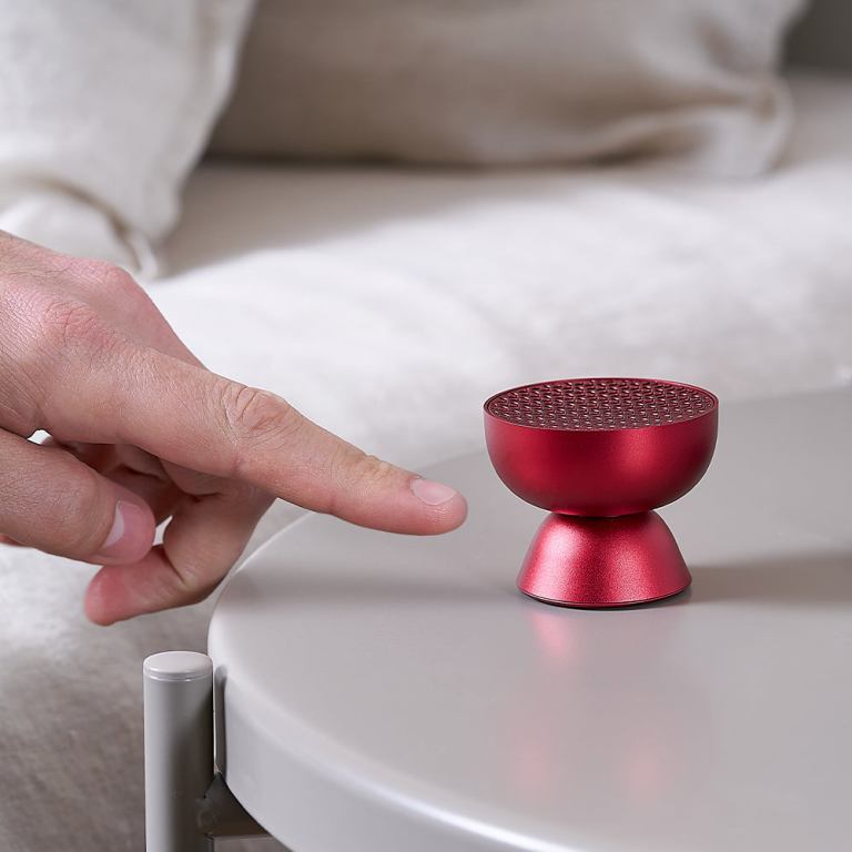 lexon tamo infinitely pairable bluetooth speaker red Finger pointing at small red speaker on table.
