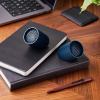 Two portable speakers on notebooks and desk.