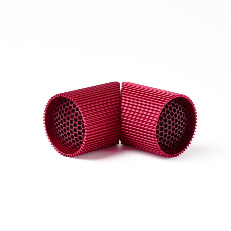 Red perforated cylindrical objects on white background.