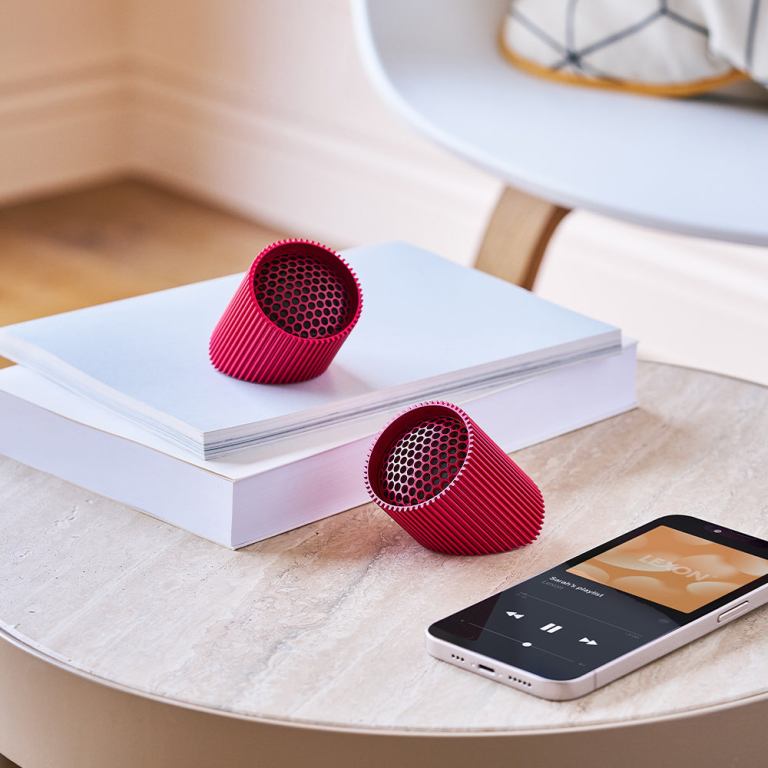 Red speakers and smartphone on table.