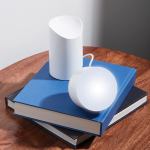 lexon orbe portable led lamp with moving head white Modern white lamp on blue books