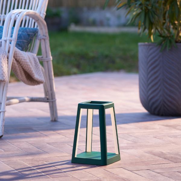 lexon lantern portable lamp with built in wireless charger green Outdoor patio with modern lantern and plant pot.