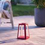 Red outdoor lantern on patio at dusk